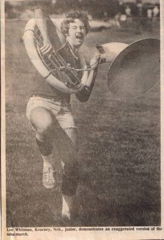 A newspaper clipping with a photo of Lee Whitman marching with a tuba