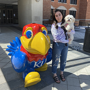 Lola and her owner, Amanda Simon, in front of a Jayhawk statue