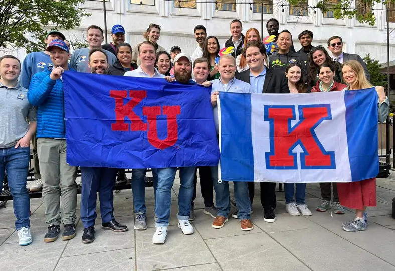 A group of DC Jayhawk alumni hold KU flags